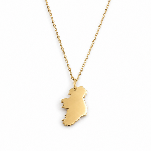 A gold necklace featuring a polished pendant shaped like the map of Ireland, suspended from a delicate gold chain against a plain white background.
